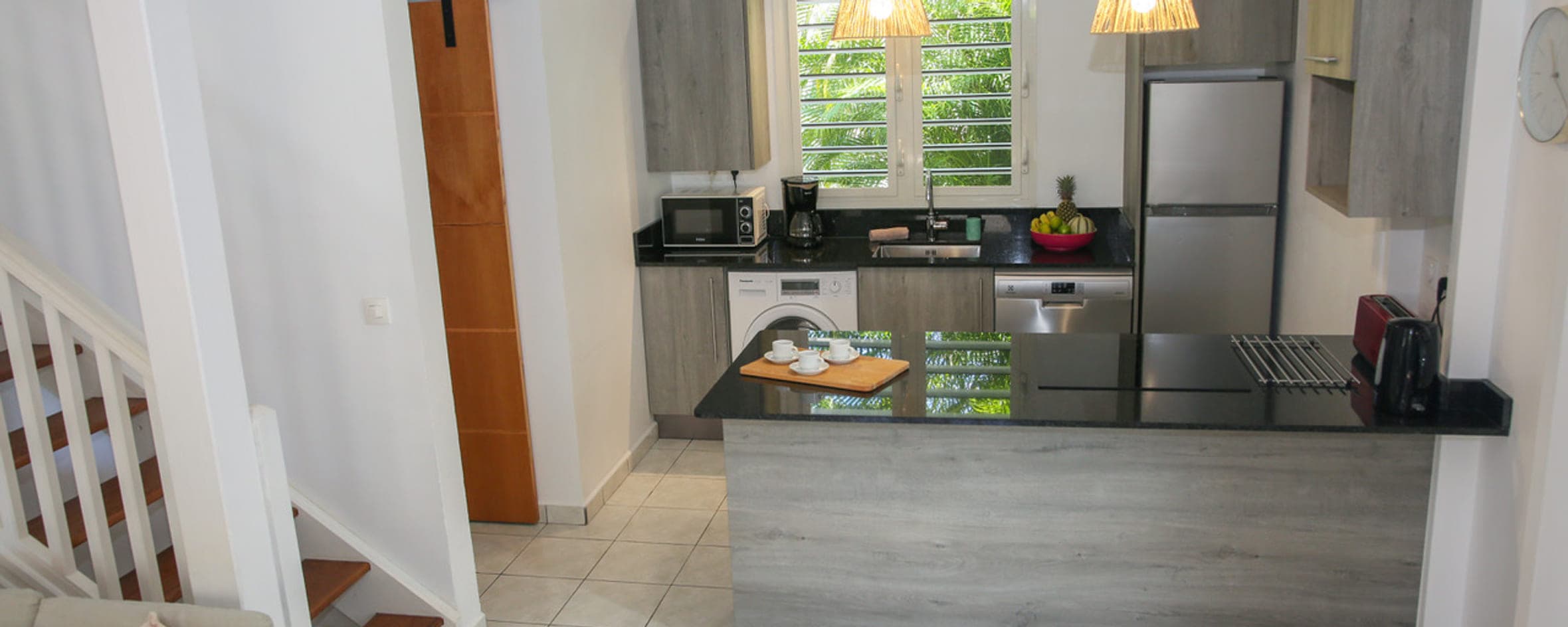 Cuisine américaine équipée de la Villa Alizé et son plan de travail noir