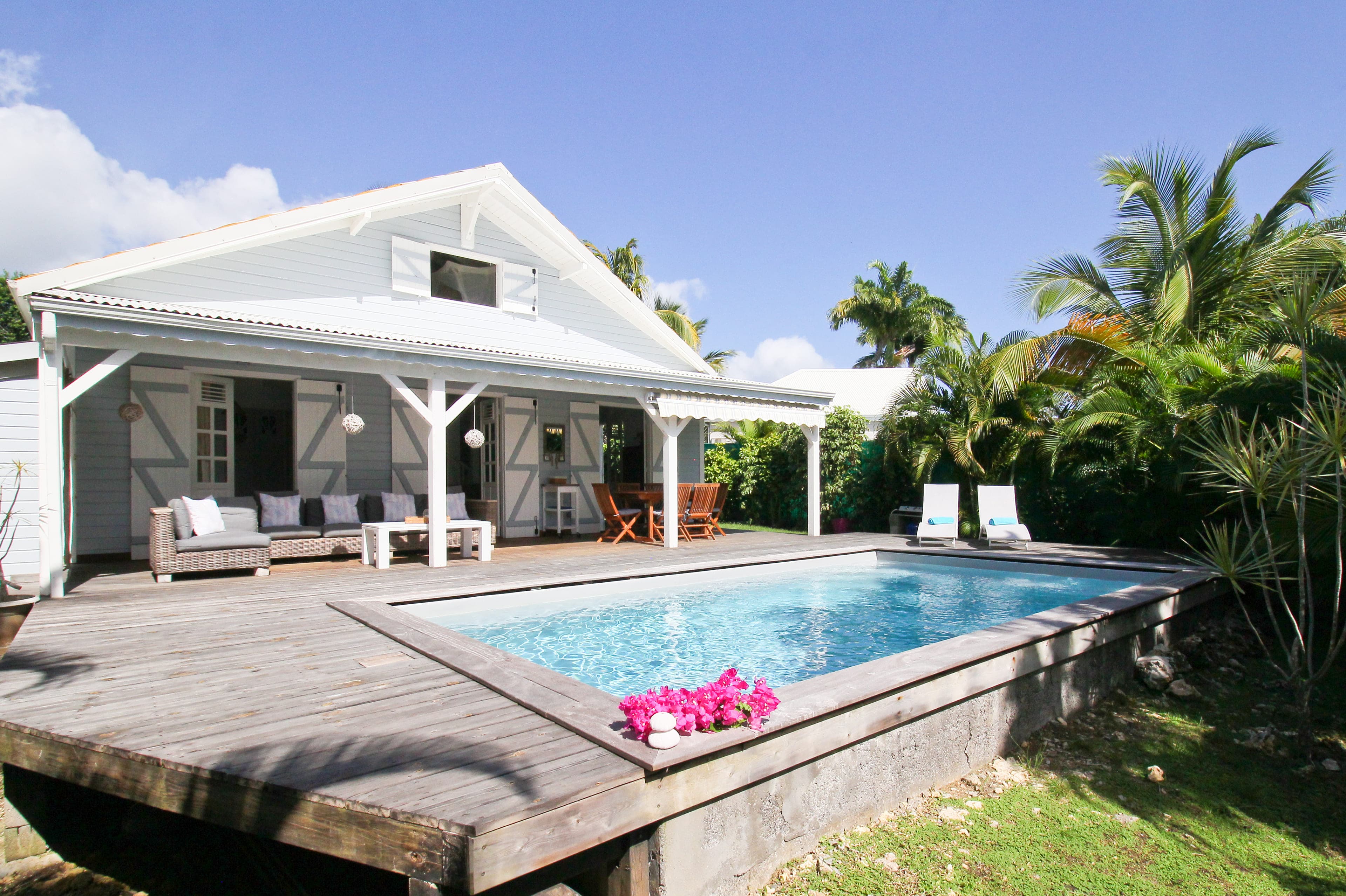 Piscine au sel de la Villa Alizé vue au ras de l’eau, terrasse couverte et bains de soleil