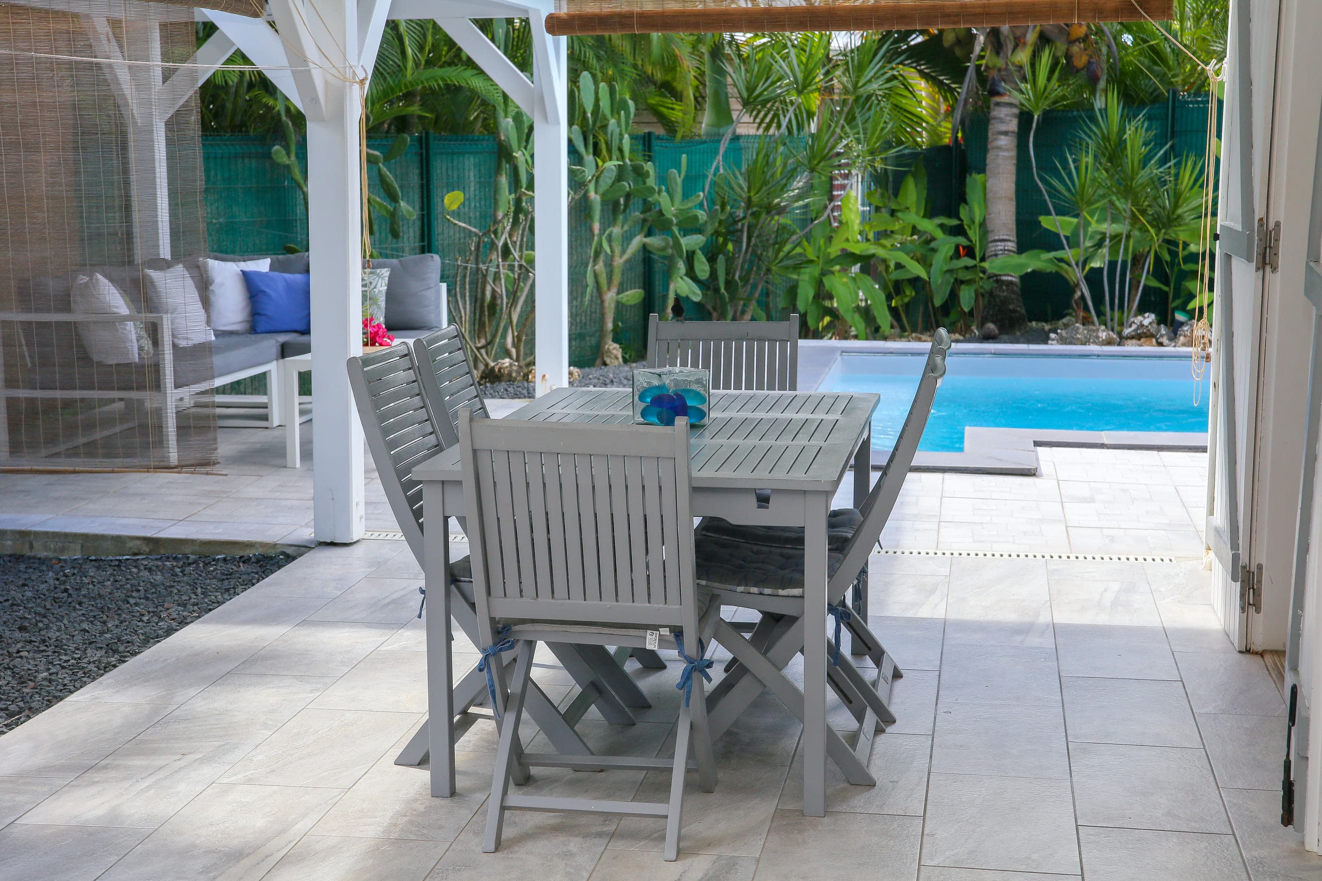 Le coin repas extérieur de la Villa Bahia, sa table sous la terrasse couverte, ouverte sur la piscine