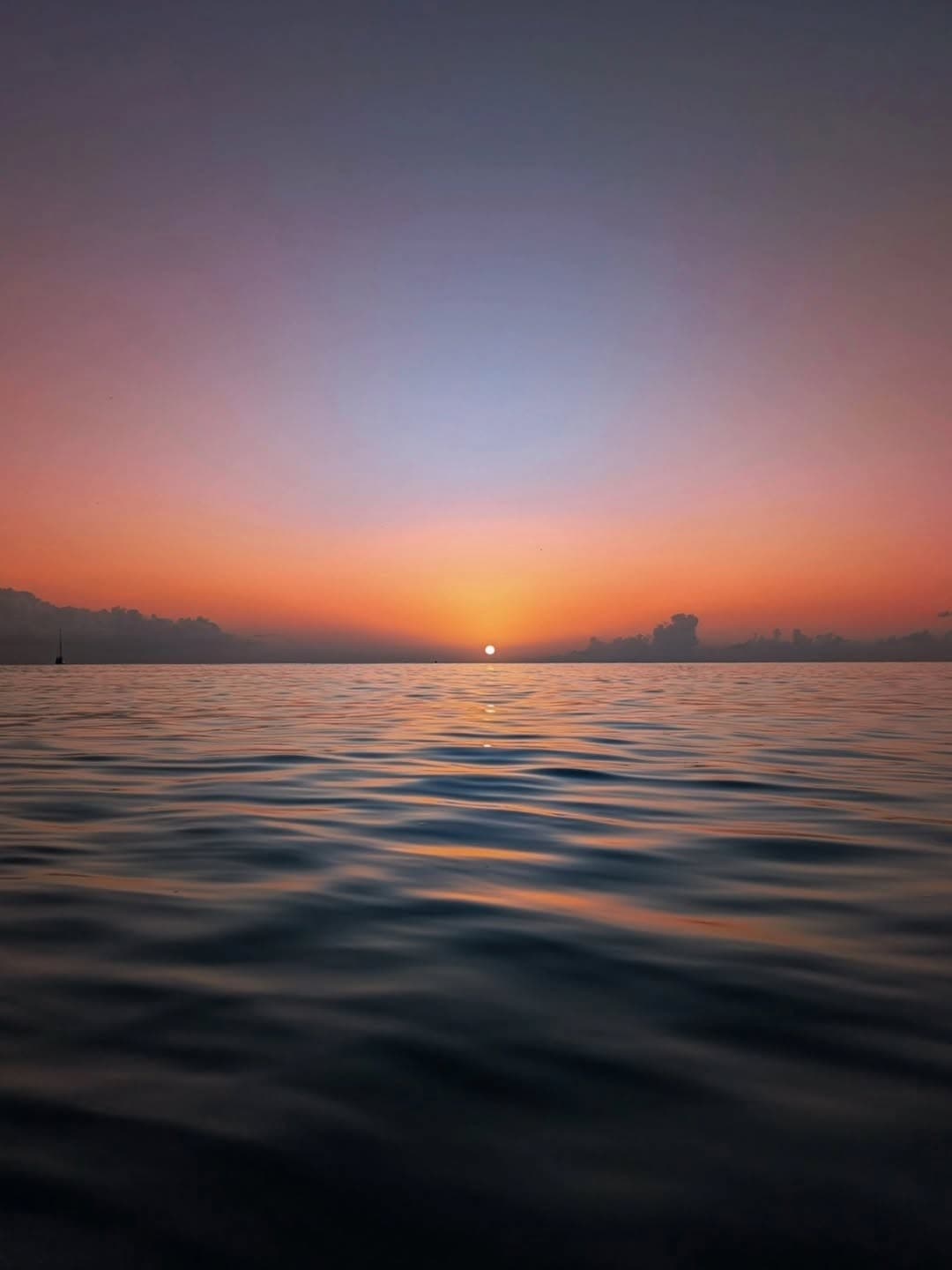 Le soleil descendant sur la mer dans un ciel rose et orangé, en Guadeloupe