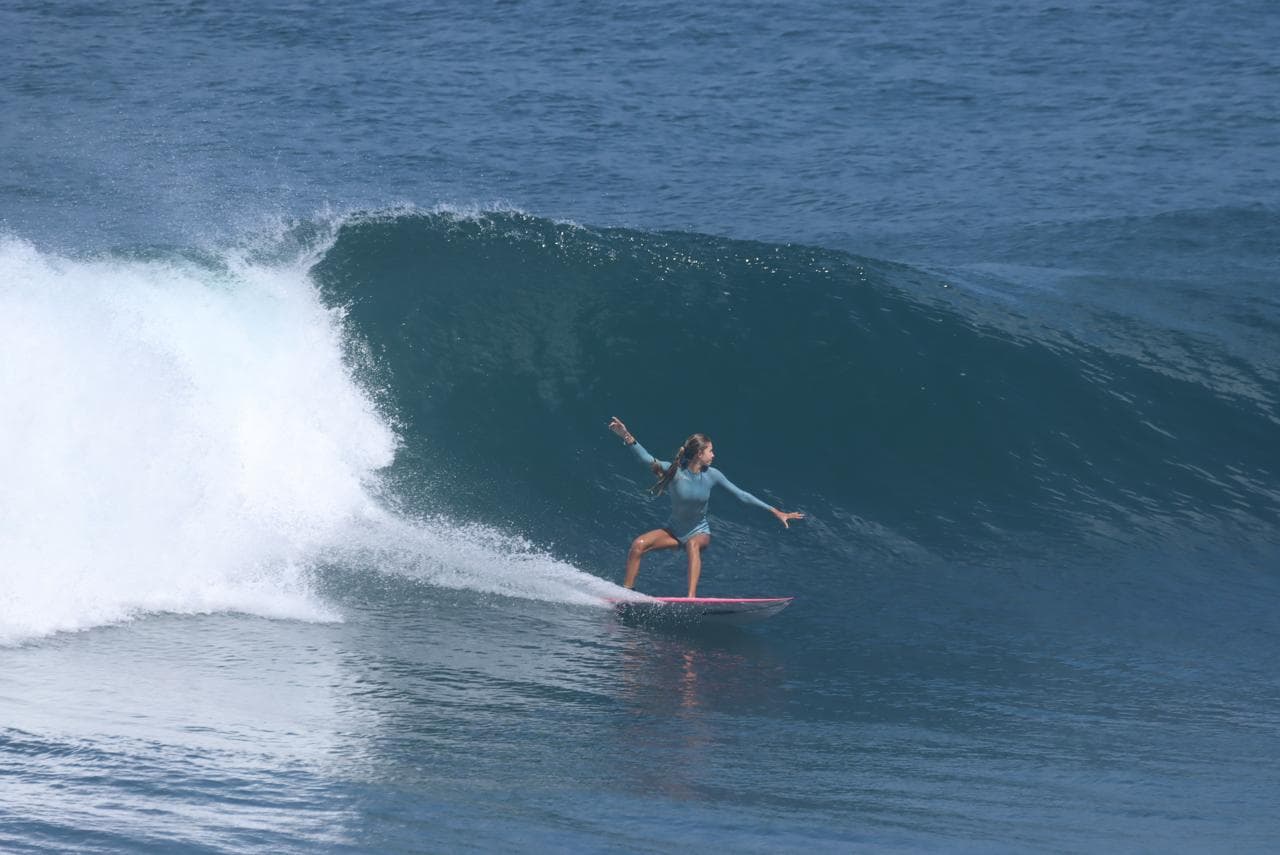 Surfeuse en appui sur la vague du spot du Helleux, à Sainte-Anne