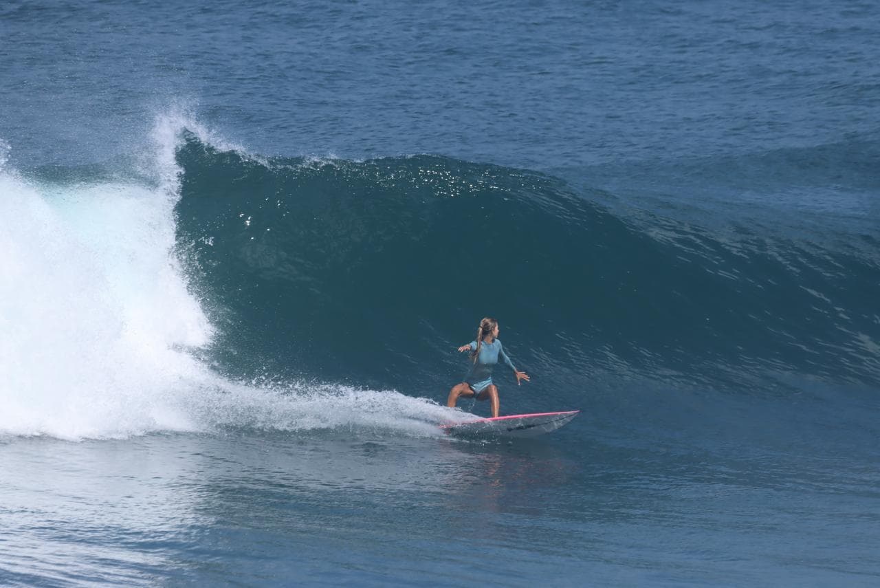 Surfeuse descendant la face d’une vague creuse sur le spot du Helleux