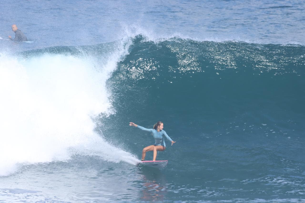 Surfeuse en équilibre sur la lèvre d’une vague à Sainte-Anne